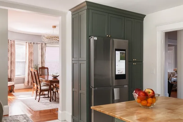 a kitchen with stainless steel appliances wooden floor and dining table