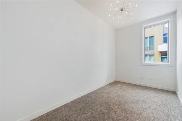 an empty room with a ceiling fan and window