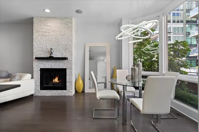 a living room with furniture a fireplace and a floor to ceiling window