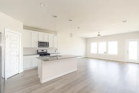 a kitchen with stainless steel appliances a stove top oven a sink a refrigerator a window