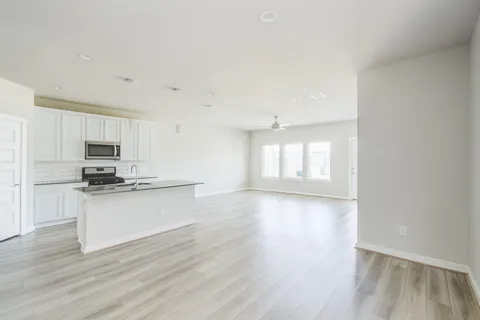 a view of kitchen with sink a microwave and stove