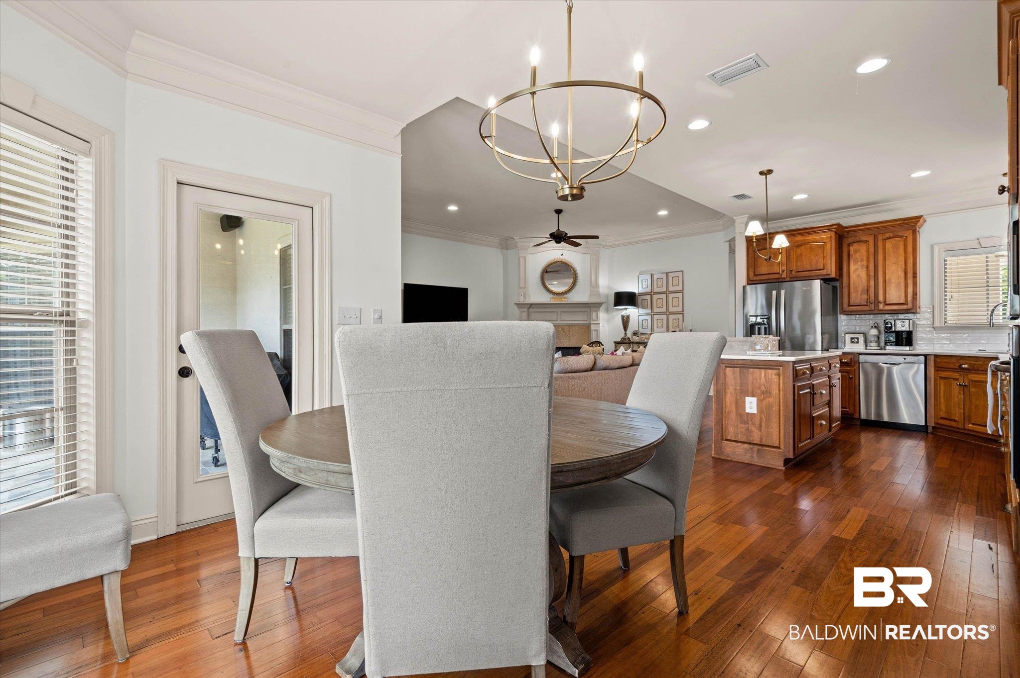 3459 Rue Royal Mobile, AL 36693 - Photo 12 of 31 Open-concept dining area featuring wood-finish flooring, a contemporary chandelier, and a glass-paneled door