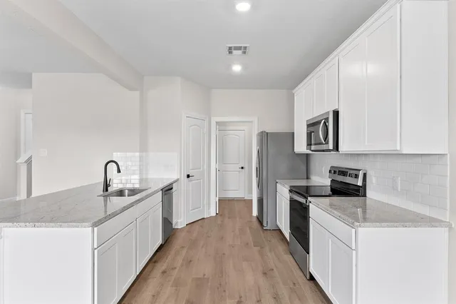 a kitchen with granite countertop a sink stove and refrigerator