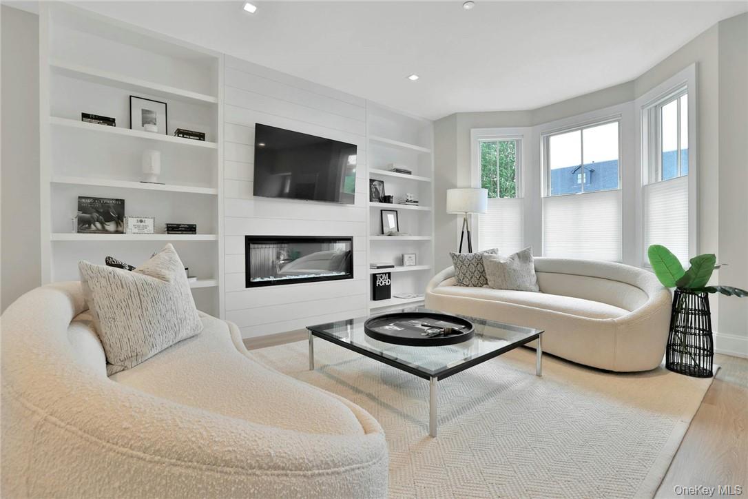 162 Bedford Road, Unit 16 Armonk, NY 10504 - Photo 3 of 37 a living room with furniture a flat screen tv and a fireplace