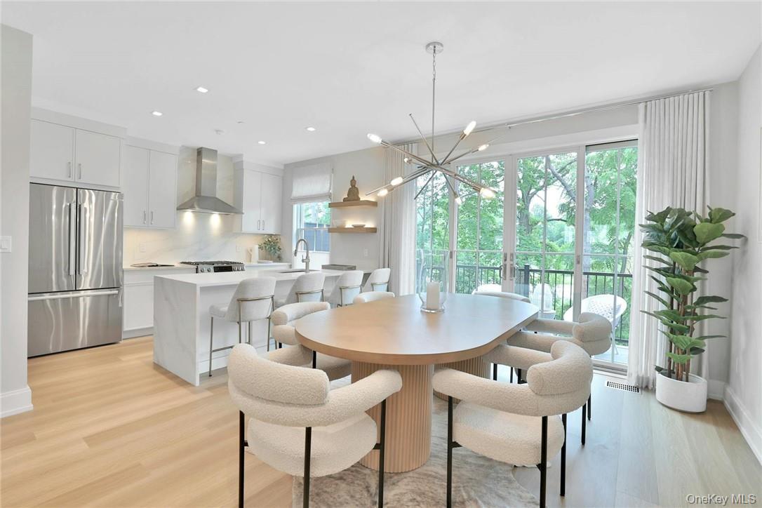 162 Bedford Road, Unit 16 Armonk, NY 10504 - Photo 5 of 37 a kitchen with stainless steel appliances granite countertop a table chairs and a wooden floor