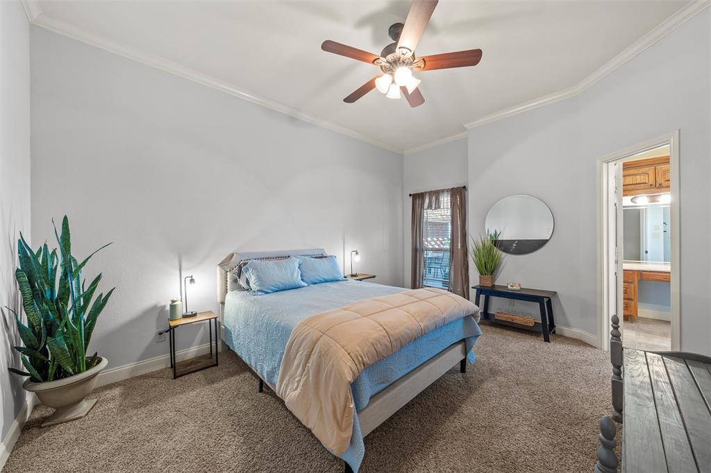 231 Trlica Road West, TX 76691 - Photo 20 of 36 This spacious bedroom features a comfortable layout and includes an en-suite bathroom, making it ideal for privacy and convenience. As the home’s original primary bedroom, it offers generous proportions and a functional design that easily accommodates a full bedroom suite. The versatile space works well as a secondary primary, guest suite, or private retreat.