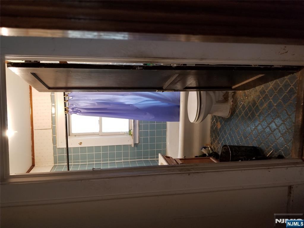 734 Broad Street Bloomfield, NJ 07003 - Photo 16 of 23 a bathroom with a toilet a window and tub