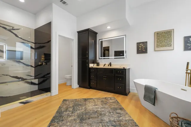 a spacious bathroom with a tub sink and mirror