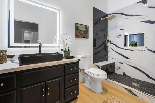 a bathroom with a sink toilet vanity and shower