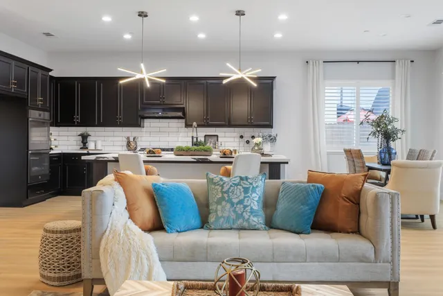 a living room with furniture kitchen and a flat screen tv