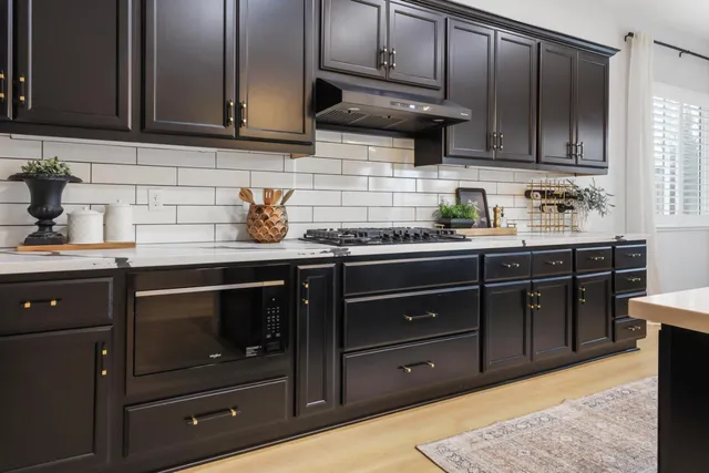 a kitchen with stainless steel appliances granite countertop wooden cabinets and a stove top oven