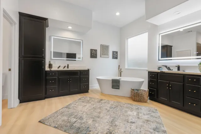 a large bathroom with double vanity and a bathtub