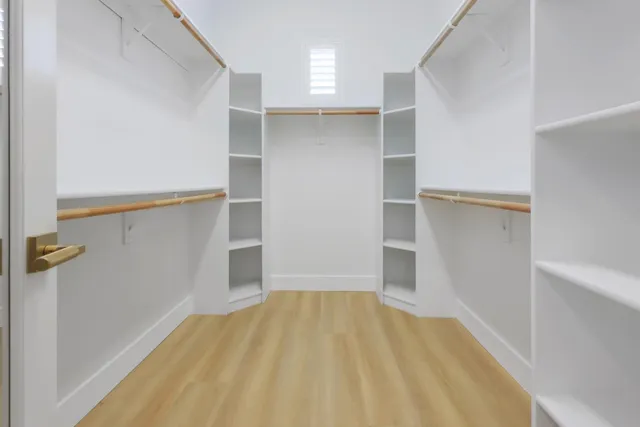 a view of an empty room with closet and a window