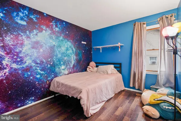 a bedroom with a bed and a wooden floor