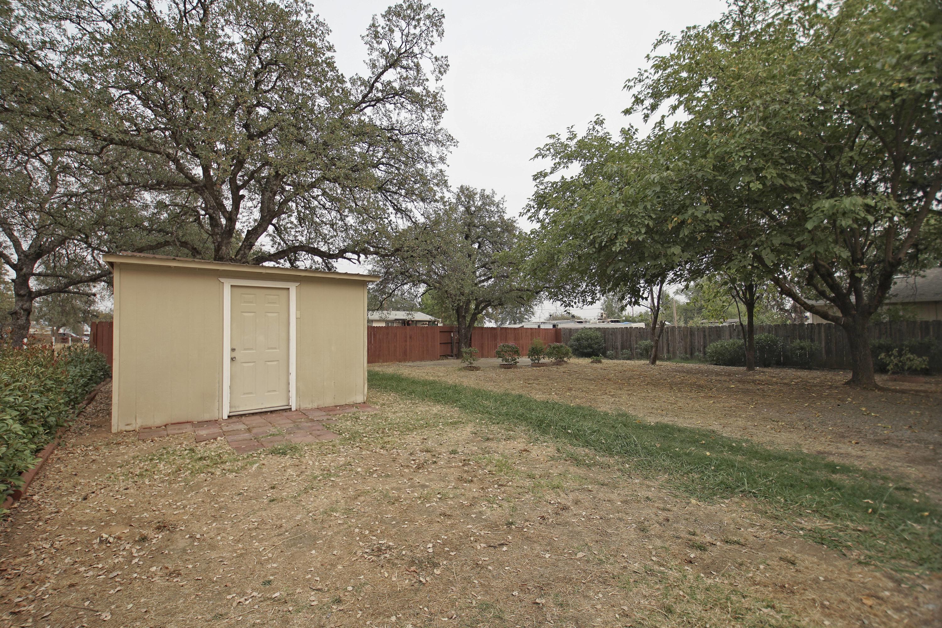11831 Scott Road Redding, CA 96003 - Photo 18 of 22 a view of a house with a large tree and a yard
