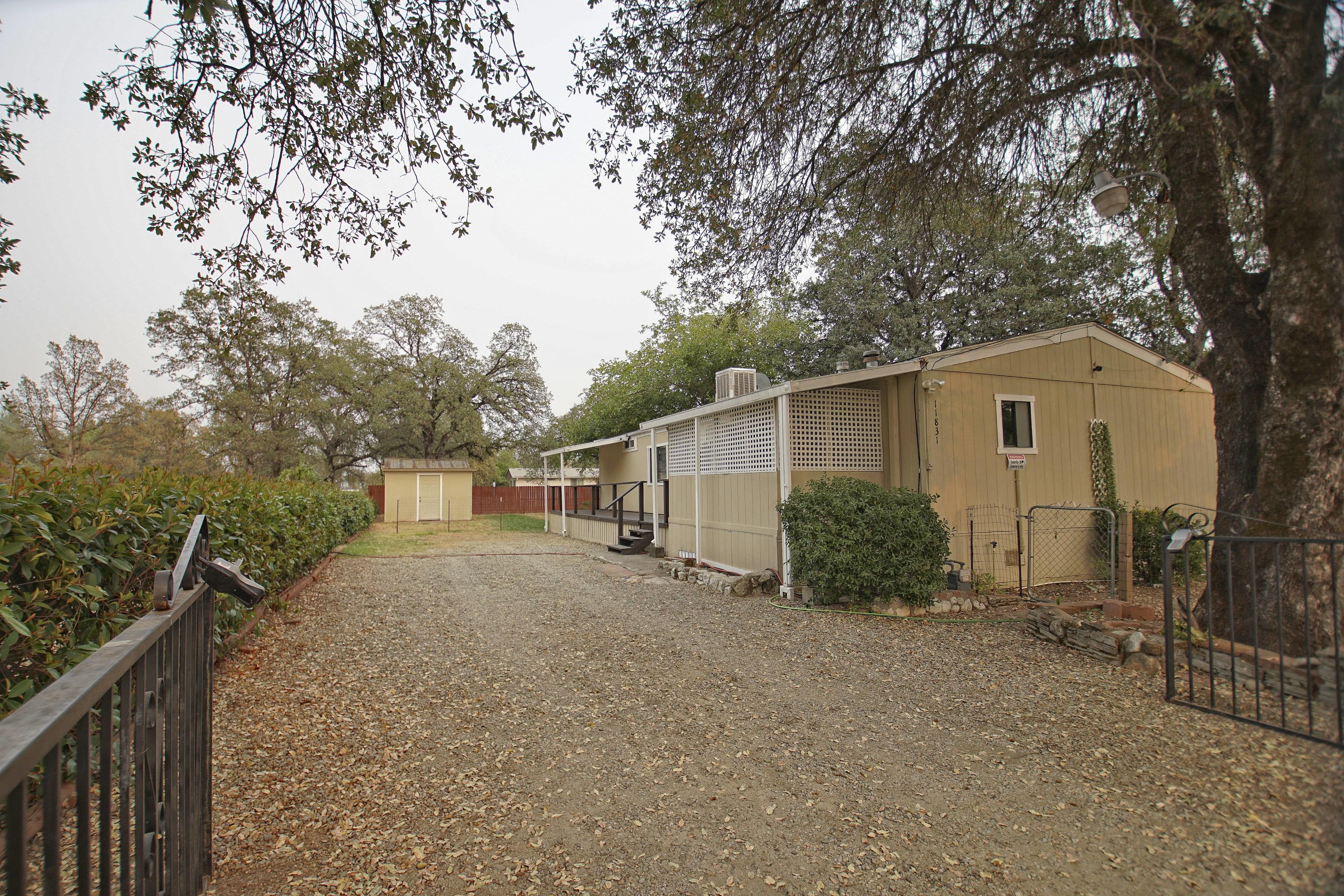 11831 Scott Road Redding, CA 96003 - Photo 2 of 22 a view of a house with a large tree and wooden fence