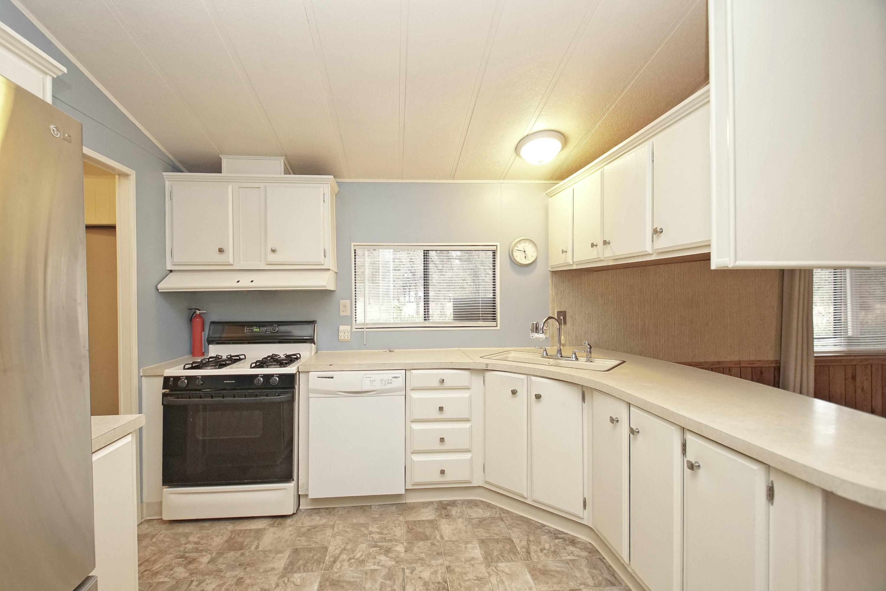 11831 Scott Road Redding, CA 96003 - Photo 5 of 22 a kitchen with white cabinets and white appliances