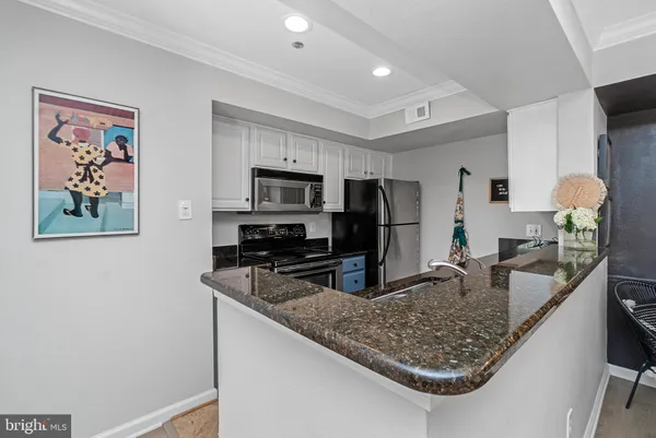 a kitchen with stainless steel appliances granite countertop a sink refrigerator and microwave