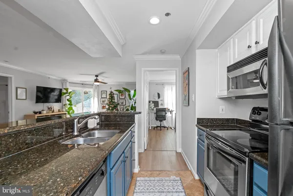a kitchen with granite countertop a sink stove and cabinets