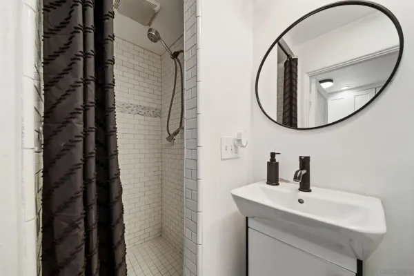 a bathroom with a sink a mirror a vanity and a shower