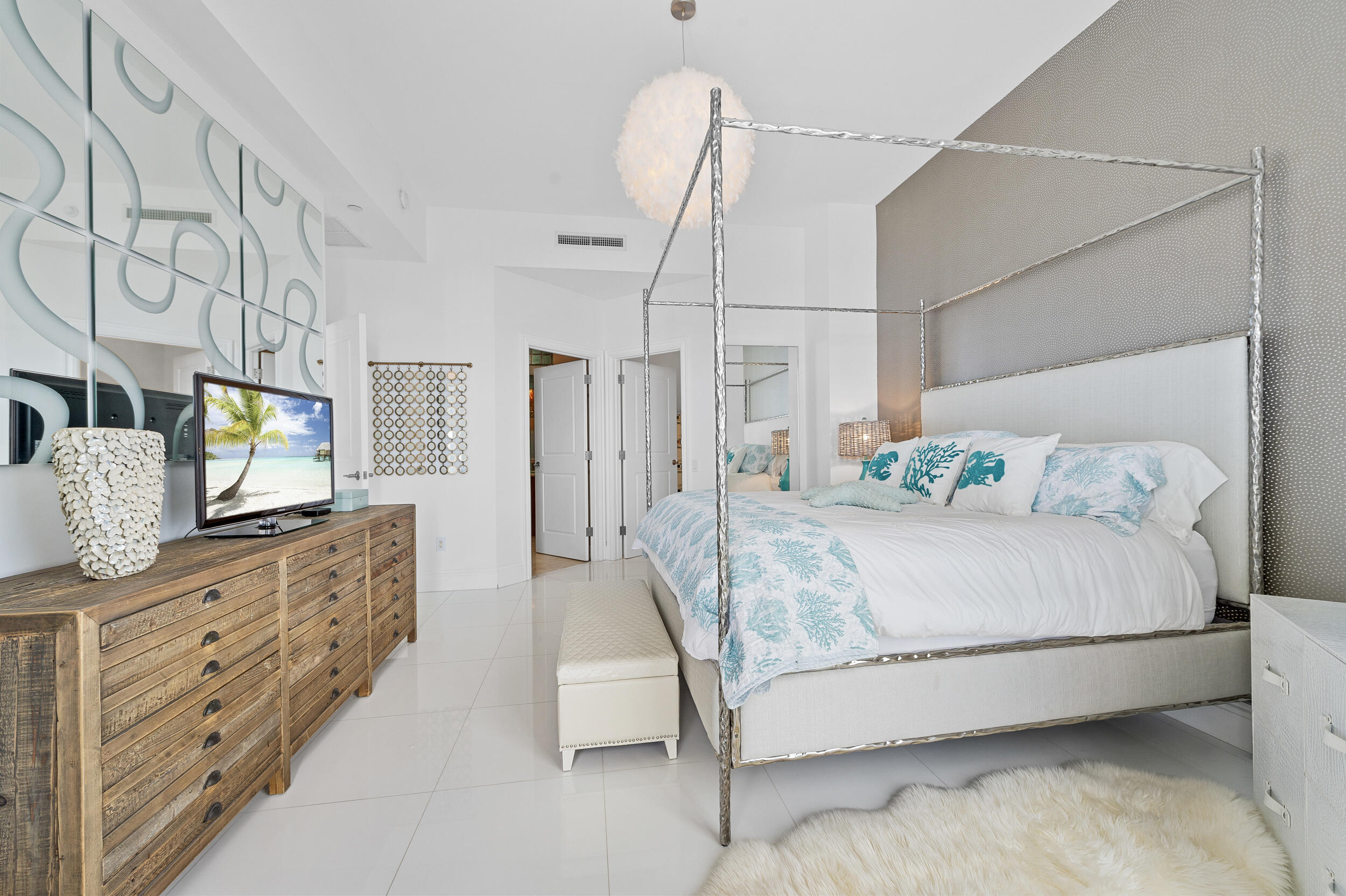 2700 North Ocean Drive, Unit PH4B Singer Island, FL 33404 - Photo 17 of 25 a spacious bedroom with a bed and a flat screen television