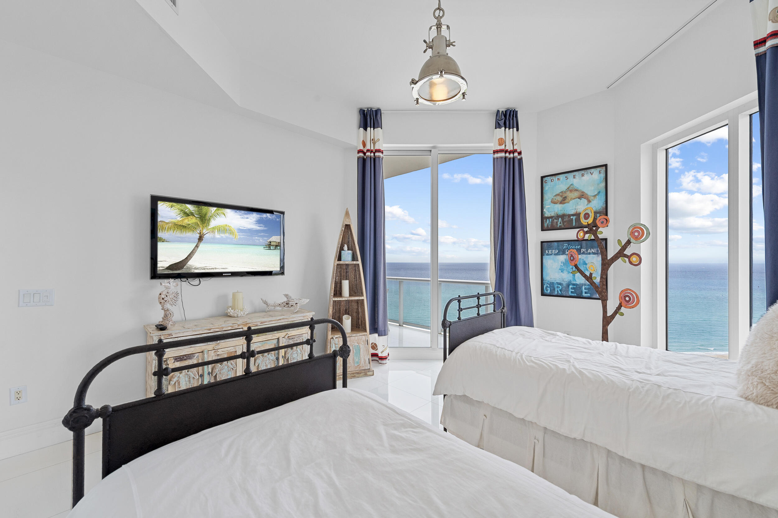 2700 North Ocean Drive, Unit PH4B Singer Island, FL 33404 - Photo 22 of 25 a bedroom with a bed and a flat screen tv