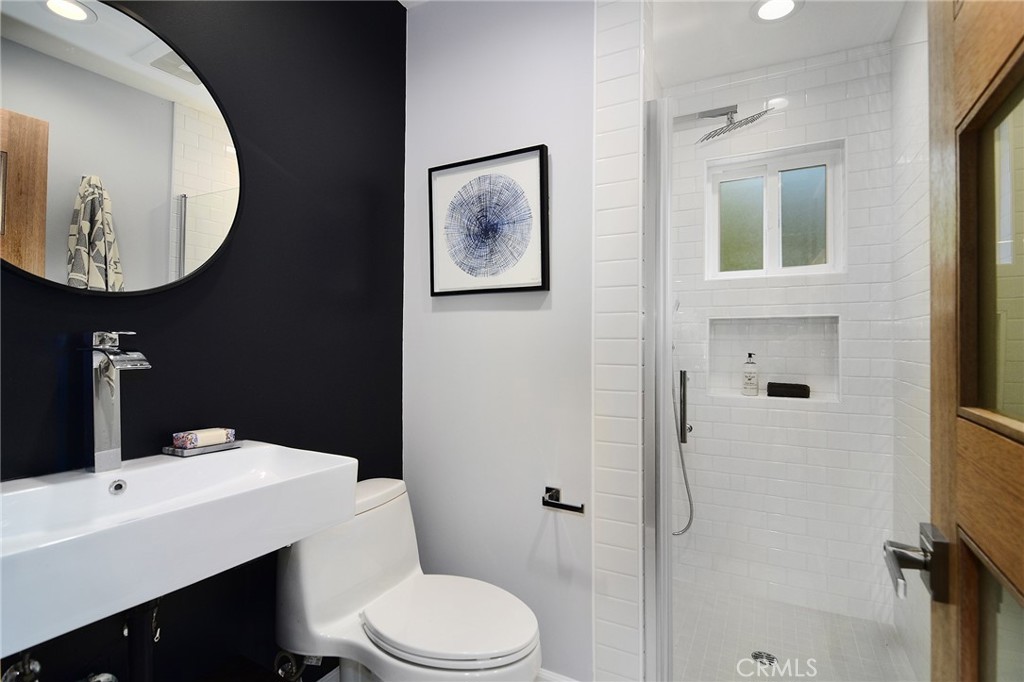 12427 Sunset Boulevard Los Angeles, CA 90049 - Photo 25 of 58 a bathroom with a toilet a sink and mirror