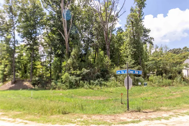a sign board with tree in the background