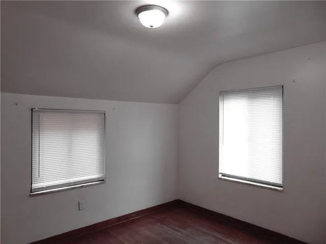 an empty room with wooden closet and windows