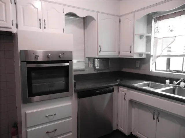 a kitchen with granite countertop white cabinets and appliances