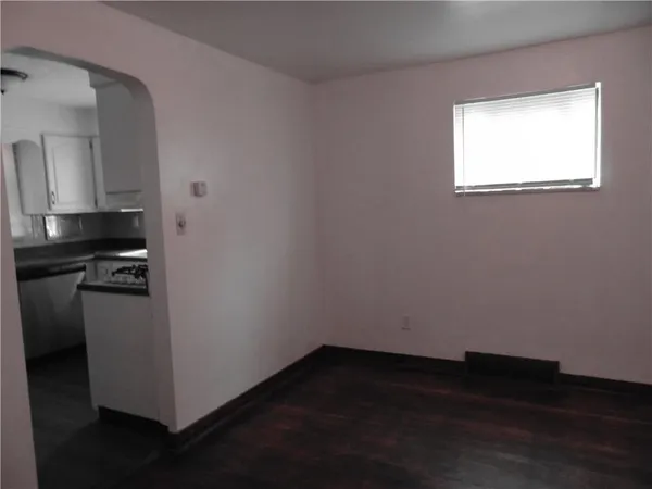 a view of a kitchen with wooden floor and a window