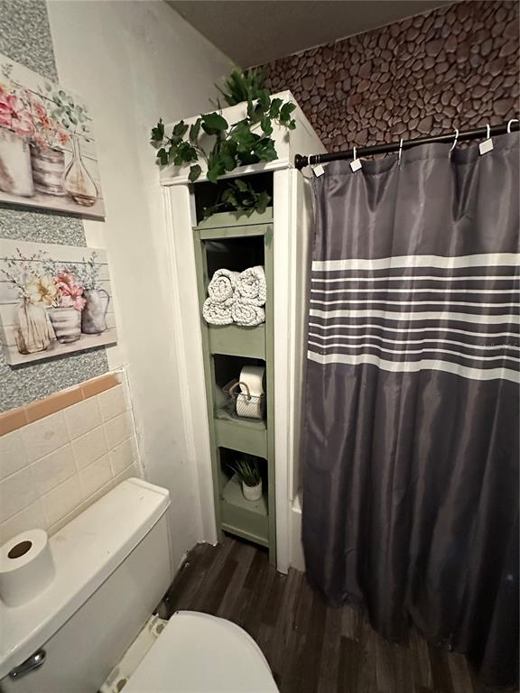 3011 South Wiggins Road Plant City, FL 33566 - Photo 11 of 17 a bathroom with a toilet and a shower curtain