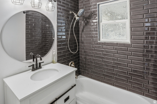 774 37th Street South Ogden, UT 84403 - Photo 18 of 47 Bathroom featuring dark subway tile shower surround, white bathtub, and a modern vanity with integrated sink