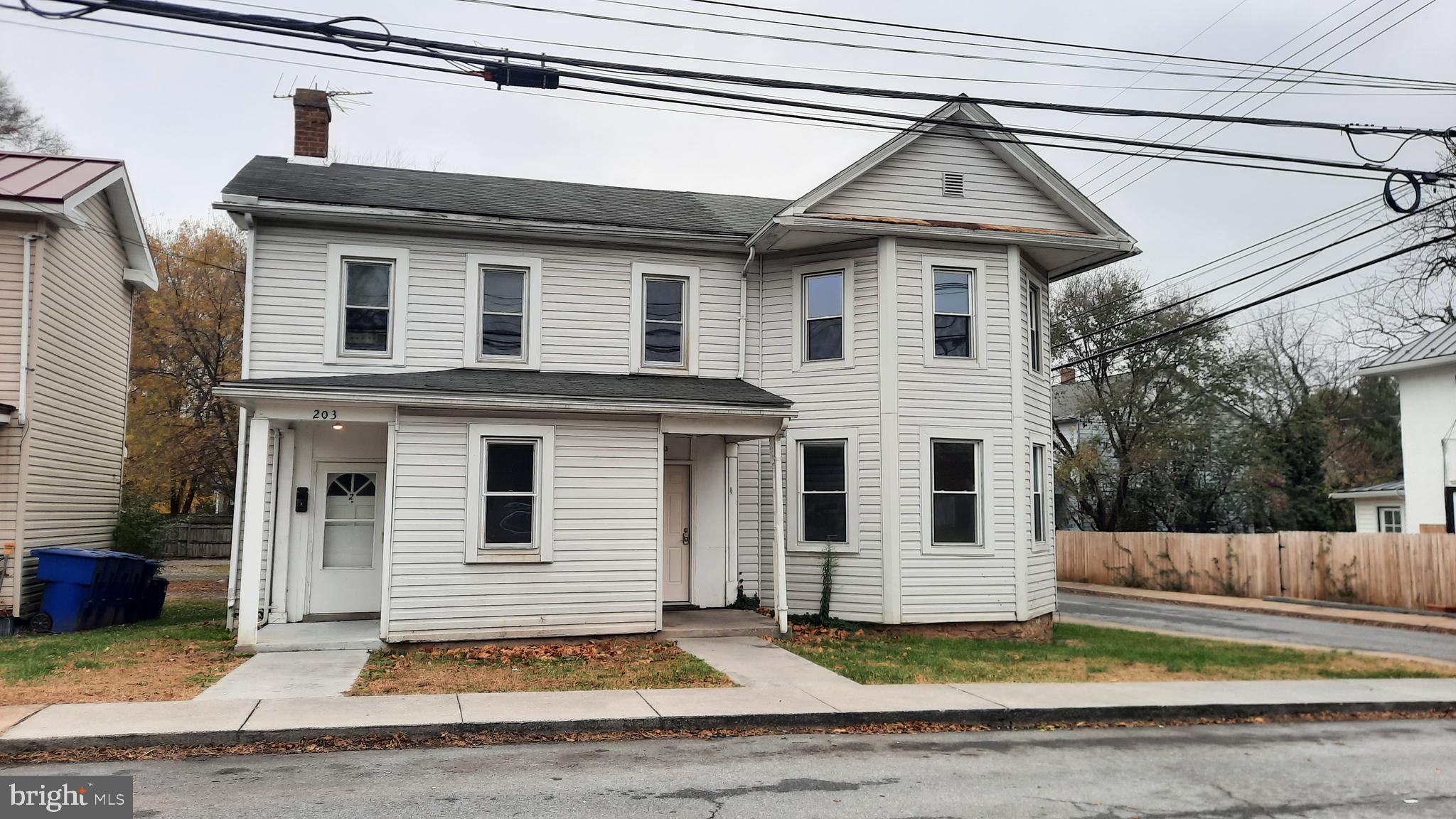 203 Cloud Street, Unit 1 Front Royal, VA 22630 - Photo 1 of 7 a view of a white house with large windows next to a road