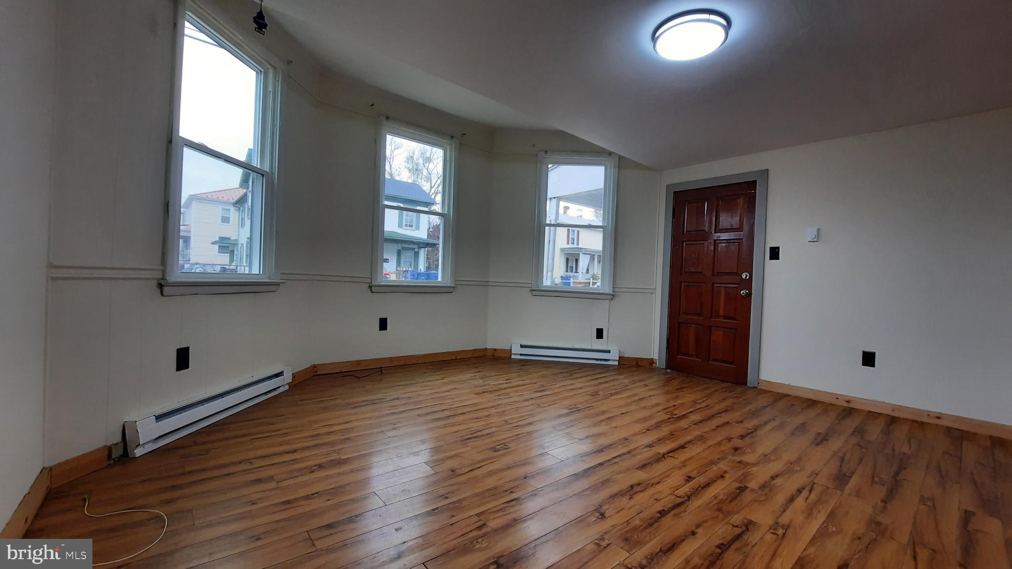 203 Cloud Street, Unit 1 Front Royal, VA 22630 - Photo 2 of 7 an empty room with wooden floor and windows