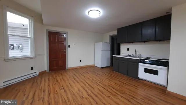 a kitchen with stainless steel appliances a stove and a wooden floor