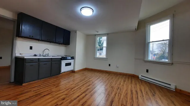 a kitchen with stainless steel appliances granite countertop a sink dishwasher a stove and a refrigerator with wooden floor