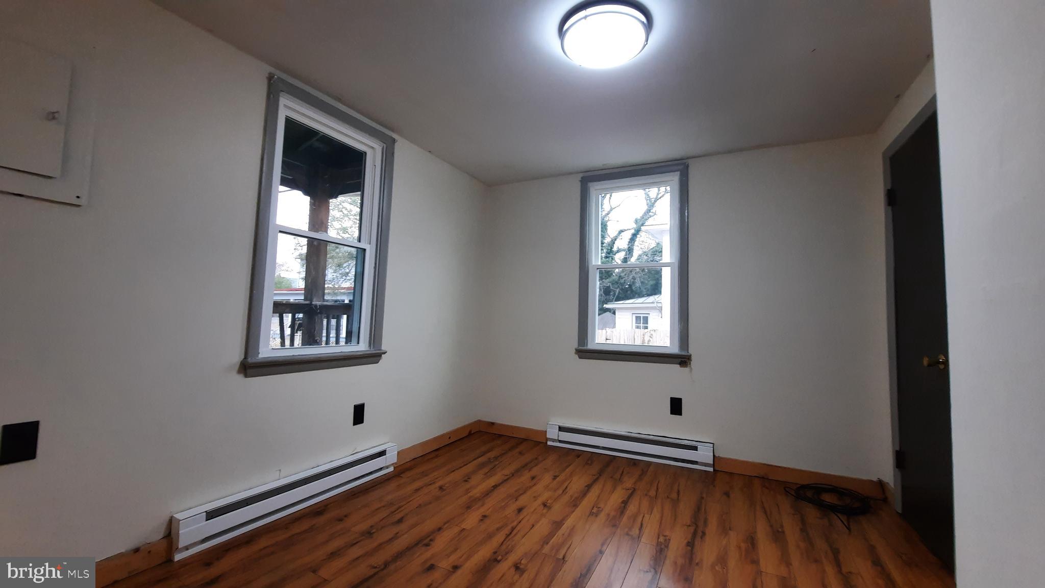 203 Cloud Street, Unit 1 Front Royal, VA 22630 - Photo 5 of 7 an empty room with wooden floor and windows