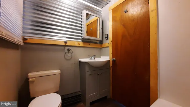 a bathroom with a sink a toilet and mirror