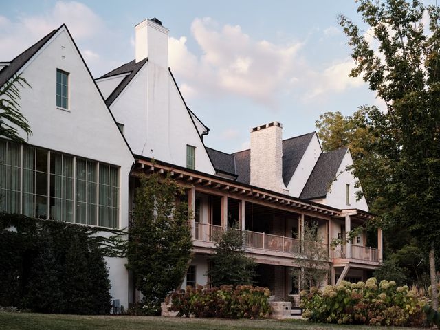 a view of a house with large windows and a small yard