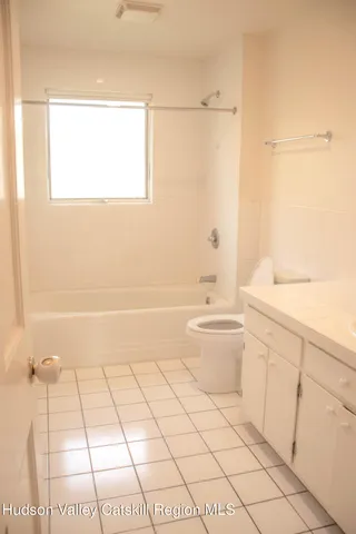 a view of empty room with wooden floor and windows