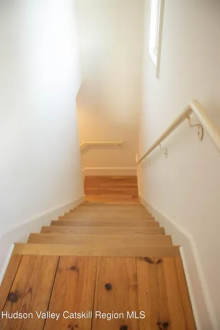 a view of a kitchen with wooden floor and a window