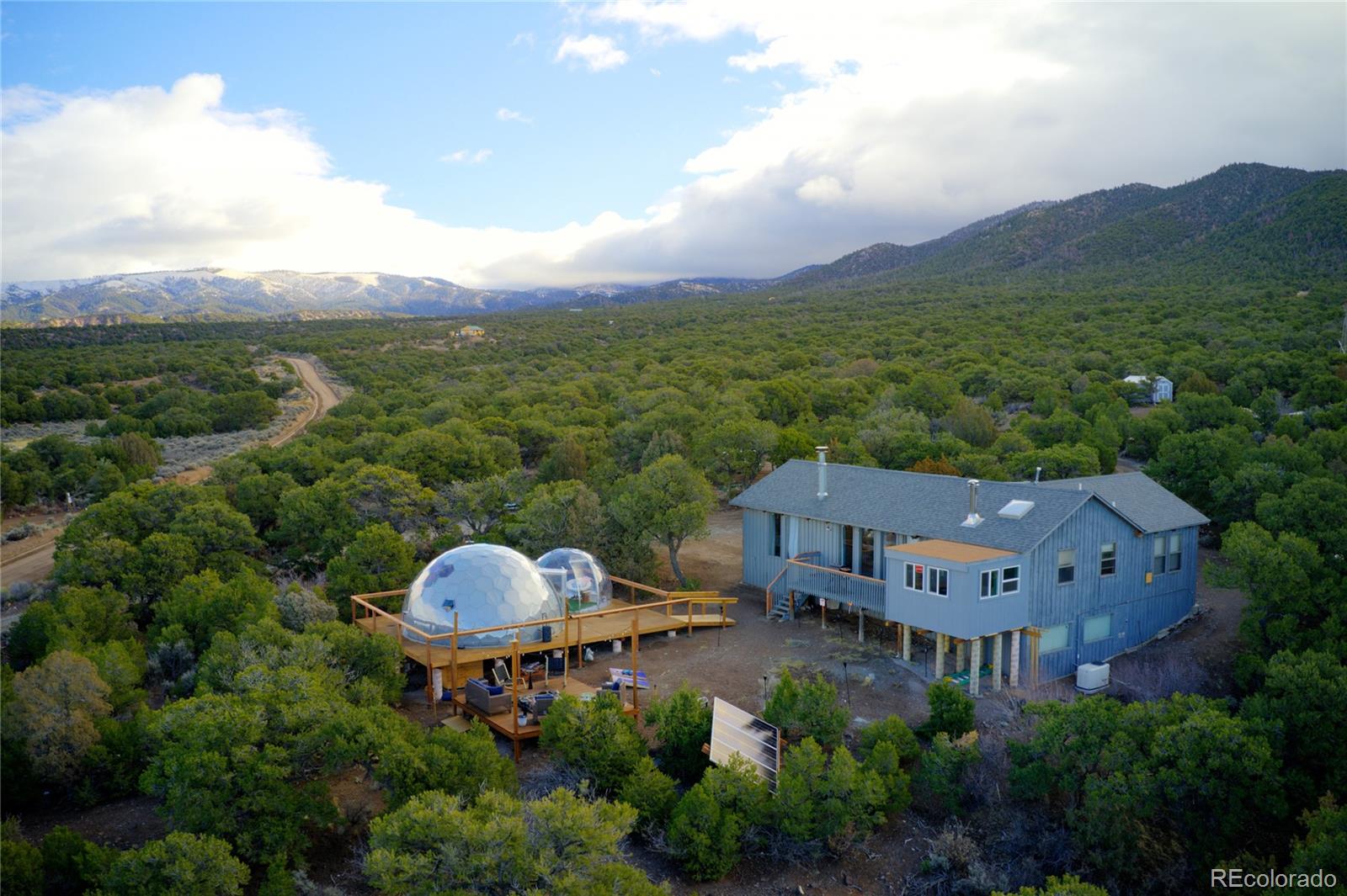 an aerial view of a house with yard and mountain view in back