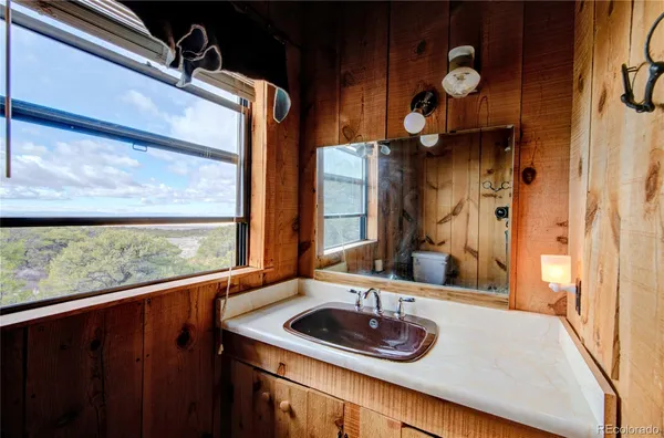 a bathroom with a granite countertop sink and a large mirror