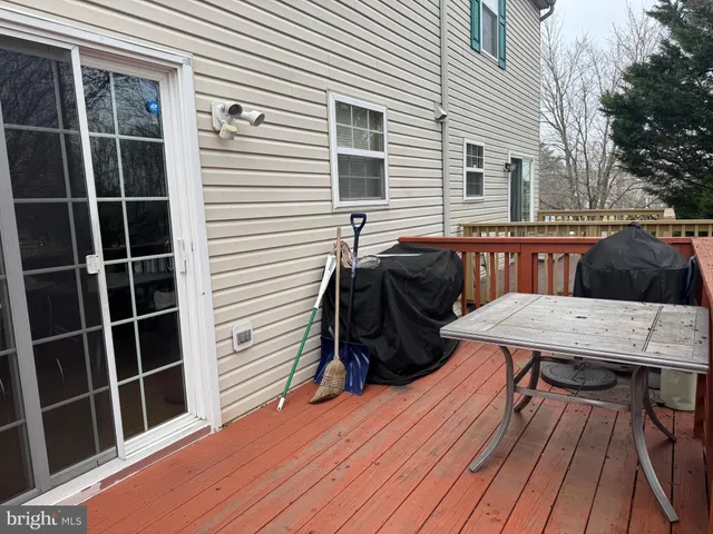 a view of a deck with table and chairs with wooden floor and fence