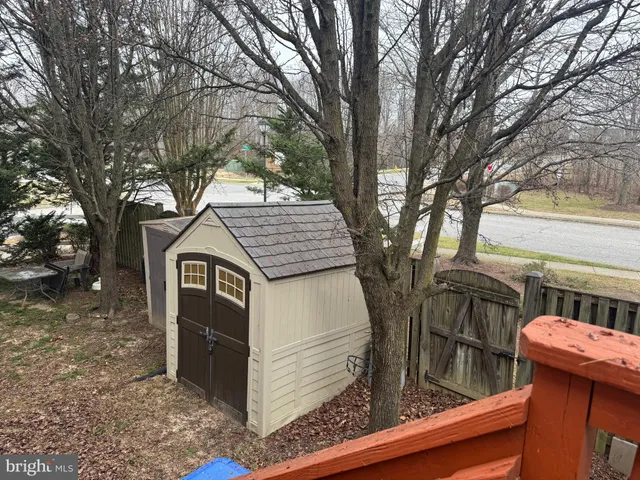 a front view of a house with yard outdoor seating and covered with trees