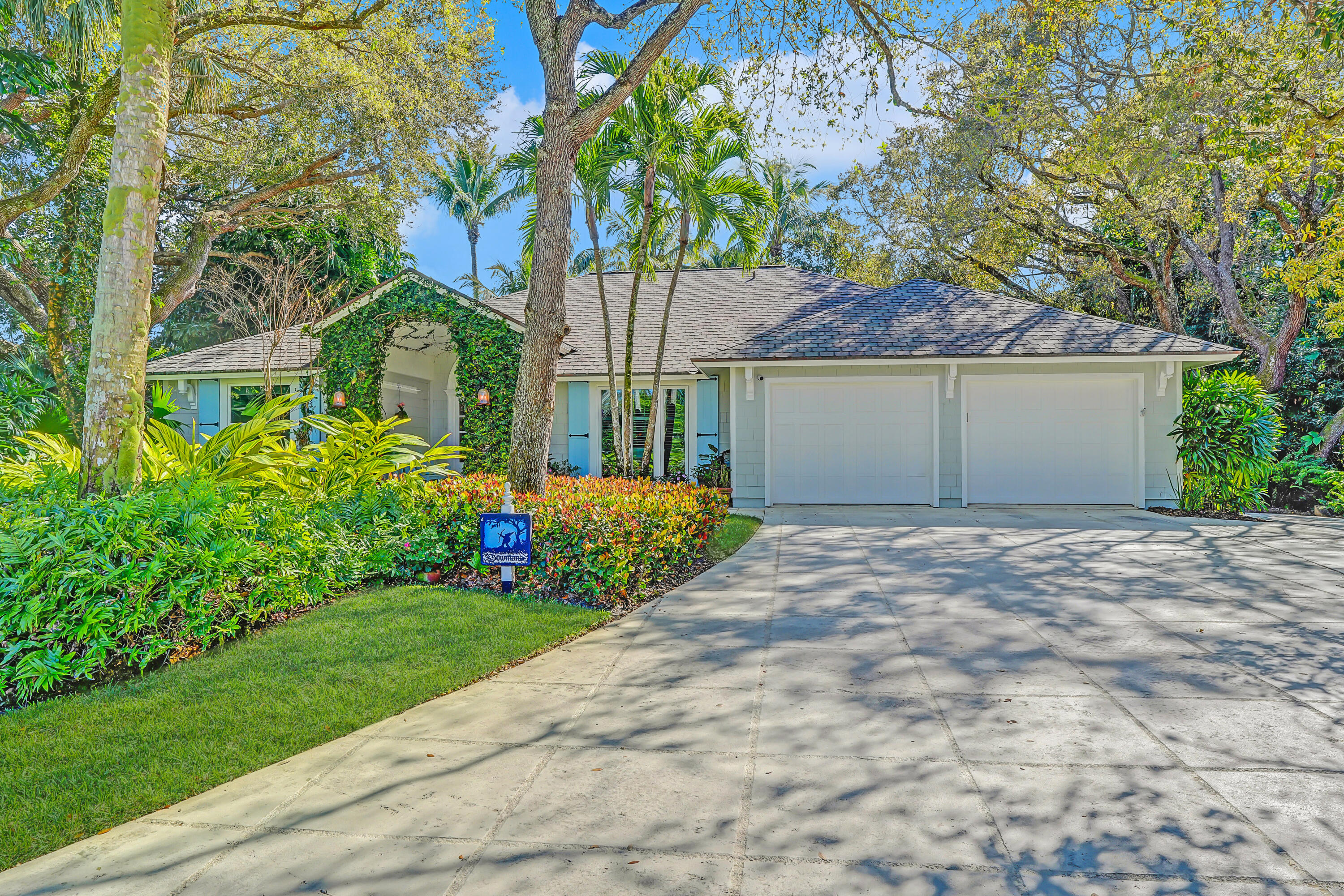 6000 Eagles Nest Drive Jupiter, FL 33458 - Photo 56 of 86 a front view of a house with a garden and yard
