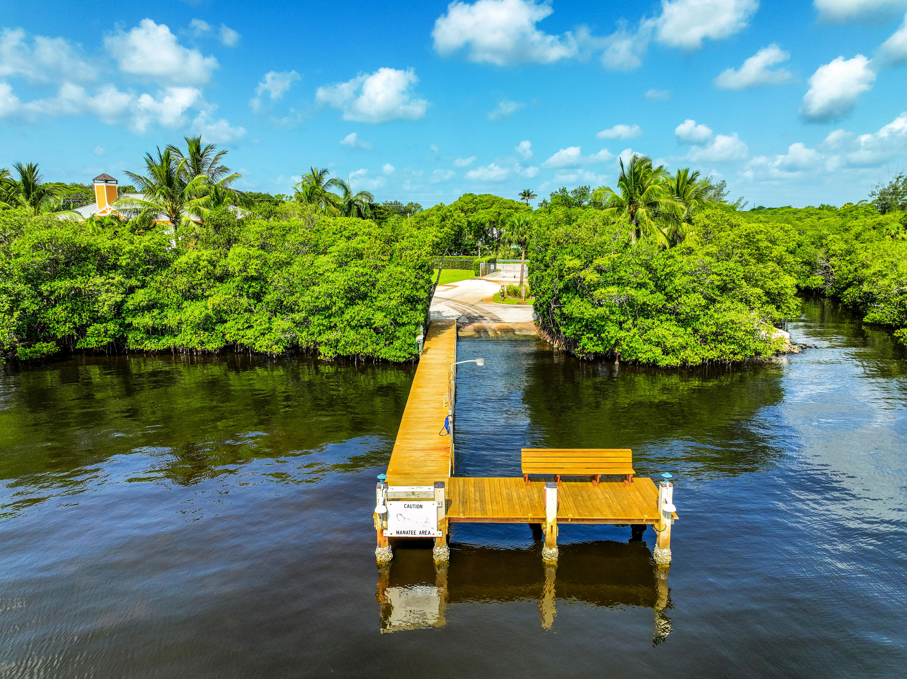 6000 Eagles Nest Drive Jupiter, FL 33458 - Photo 71 of 86 a wooden bench sitting next to a lake