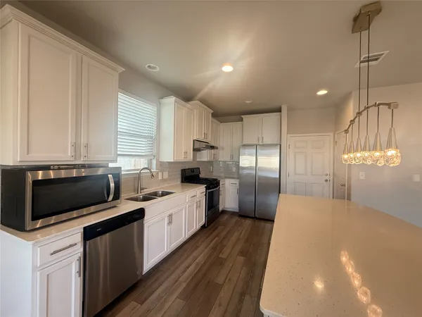 a kitchen with stainless steel appliances a refrigerator sink and microwave