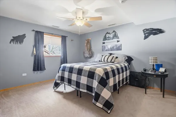 a bedroom with a bed and a lamp on the dresser